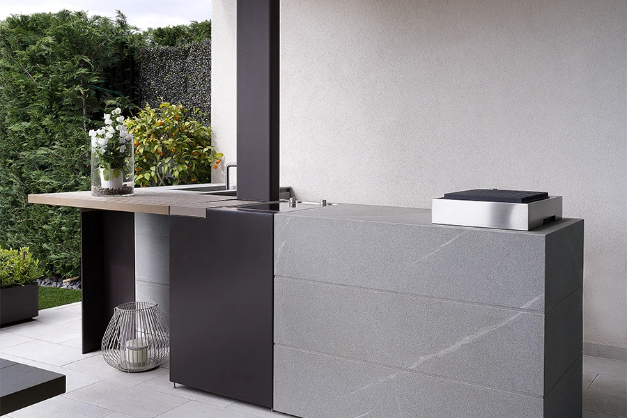 Un nuovo modo di vivere l'outdoor. Angolo cucina esterno con piano in pietra ed elementi in legno
